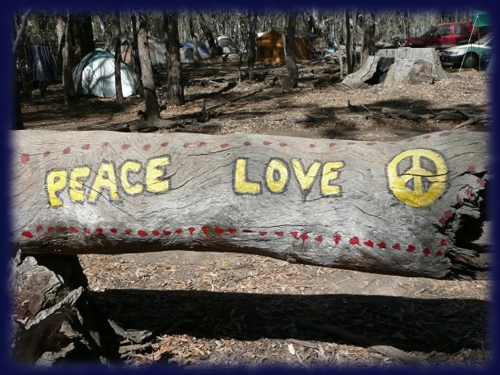 Tree log with Peace symbol and text and love painted on.